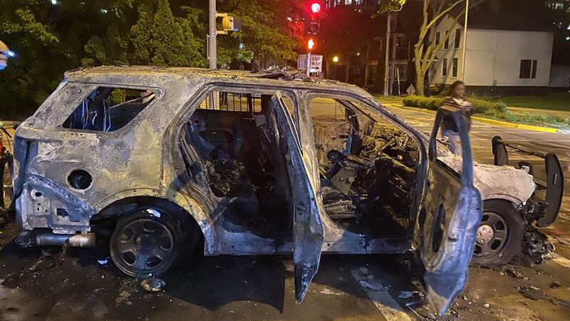 A Madison Police Dept. cruiser sits burnt after the first night of protests in downtown...