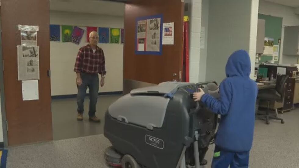 Mr. Peanuts helps 9-year-old Vaughn direct the Zamboni.