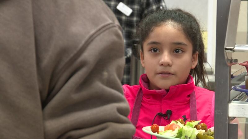 A 9-year-old volunteer serves food at the St. Martin House.