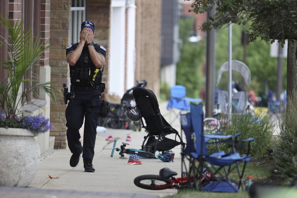 A Lake County police officer walks down Central Ave in Highland Park on Monday, July 4, 2022,...