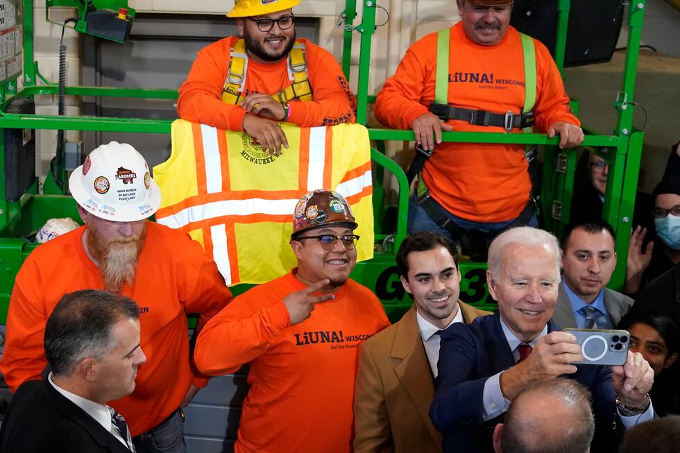 President Joe Biden takes a photo with workers after delivering remarks on his economic agenda...