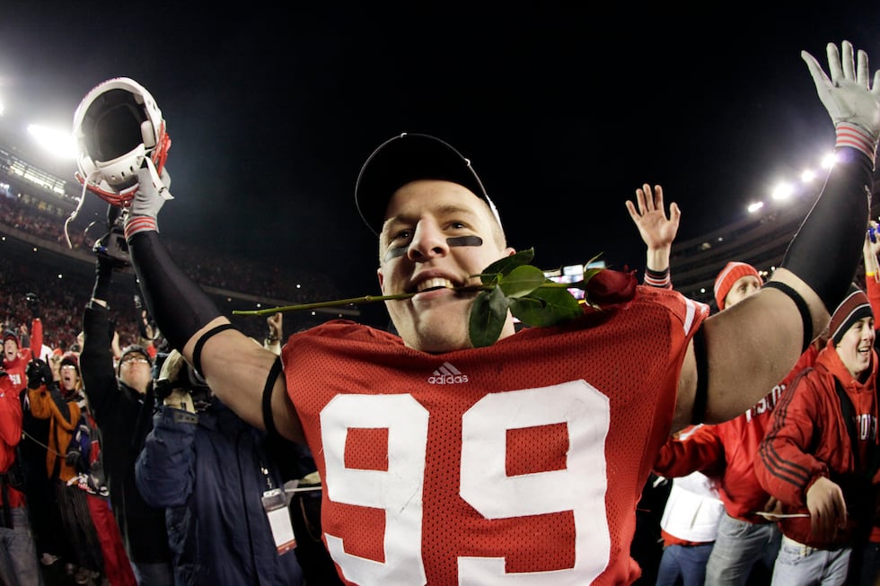 Wisconsin defensive tackle J.J. Watt bites a rose after an NCAA college football game against...