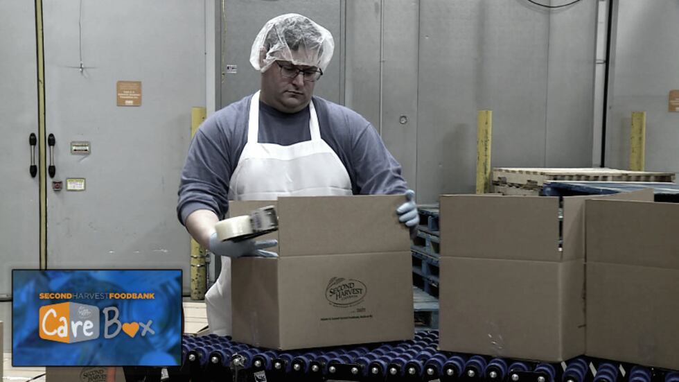 Volunteer putting together Care Boxes at Second Harvest Foodbank of Southern Wisconsin. (WMTV)